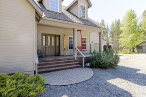 A house with a front porch, steps leading to the door, a red fire hose, and a small tree. - Aspen Place 3 Bedroom Home (Bend)