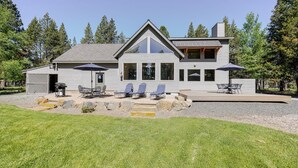 A modern two-story house with a patio area featuring outdoor furniture and umbrellas. - Aspen Place 3 Bedroom Home (Bend)