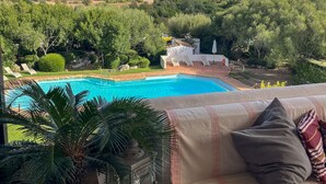 A pool with a view of the sea, a covered seating area, and lush greenery. - Romantic Suite Apt.21 - Olbia (Olbia)