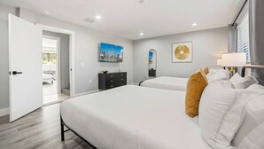 A hotel room with two beds, a dresser, a painting, and a view of a balcony. - Heated Pool - Putting Green - 5 min From Beach! (Deerfield Beach)