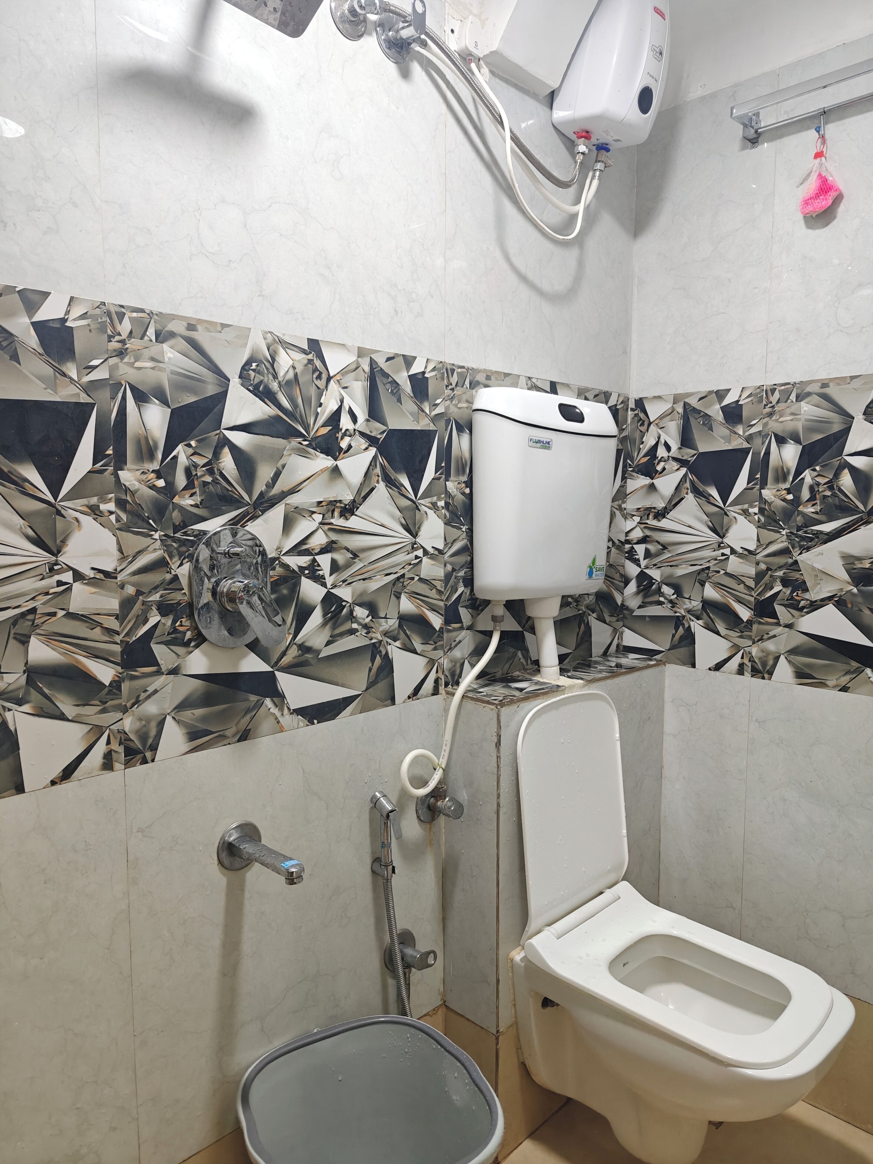 A bathroom with a toilet, a bidet, and a hand dryer.