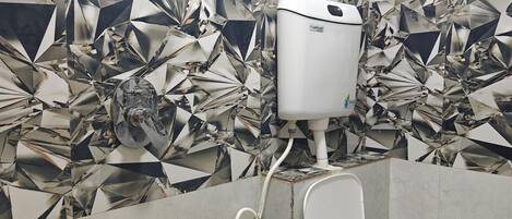 A bathroom with a toilet, a bidet, and a hand dryer.