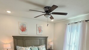 A bedroom with a bed, nightstands, a ceiling fan, and a window with curtains. - 4 Blocks to Beach/Pleasure Pier-1 Block off parade route-KING Suite-Allow Pets (Galveston)