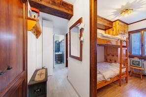 A room with a bunk bed, wooden furniture, a small table, and a mirror. - Casetta del Caregòn with Panoramic Terrace Overlooking Monte Pelmo, UNESCO Dolomites (VODO CADORE)
