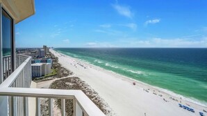 A beach view from a balcony with a clear sky, a sandy beach, and ocean waves. - Relax & Recharge in This 19th-Floor Getaway (Panama City Beach)