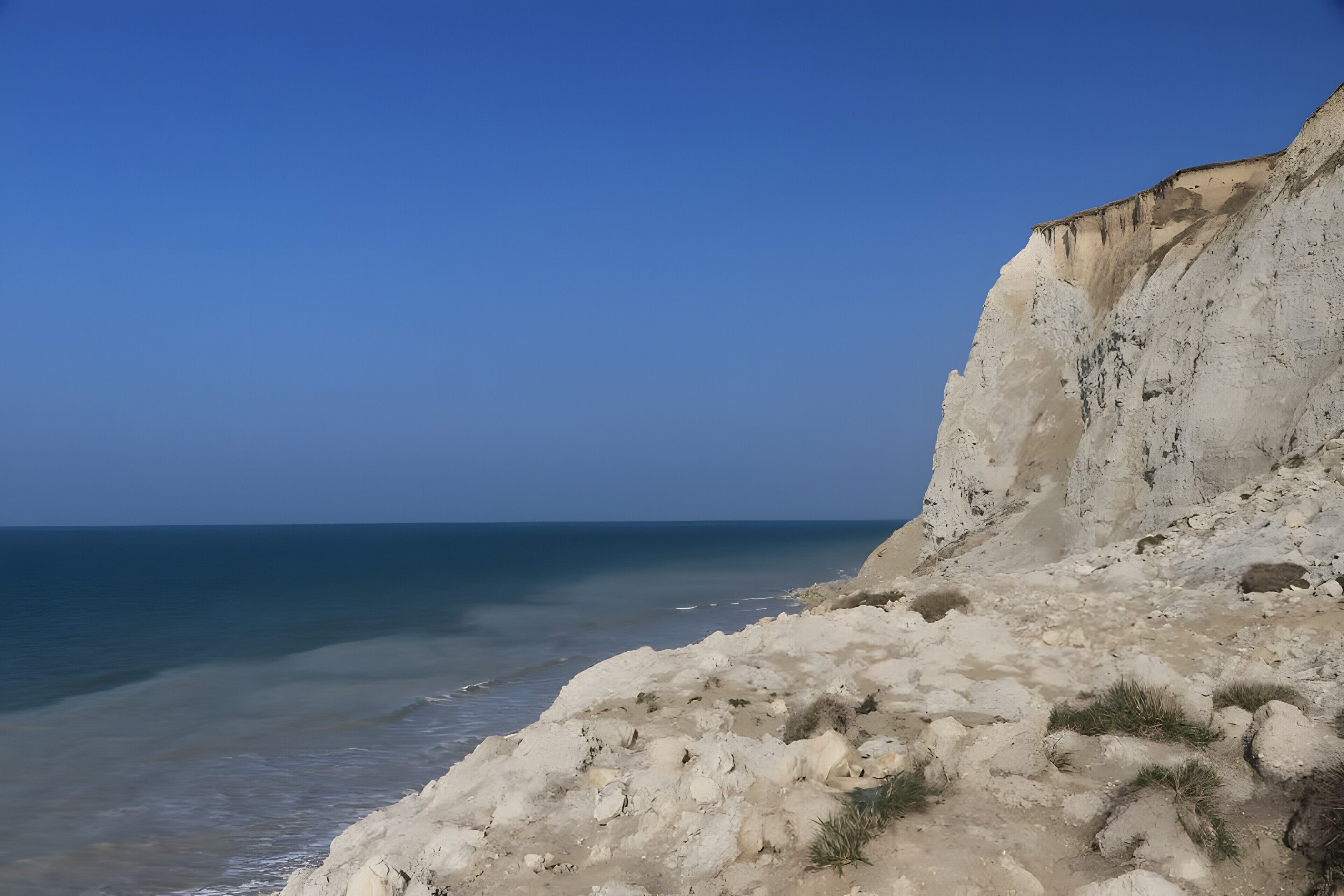 Un paysage côtier avec une falaise et la mer.