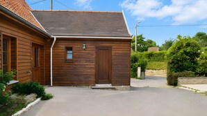 Un bâtiment en bois doté d’un toit en pente, d’une porte et d’une petite fenêtre.