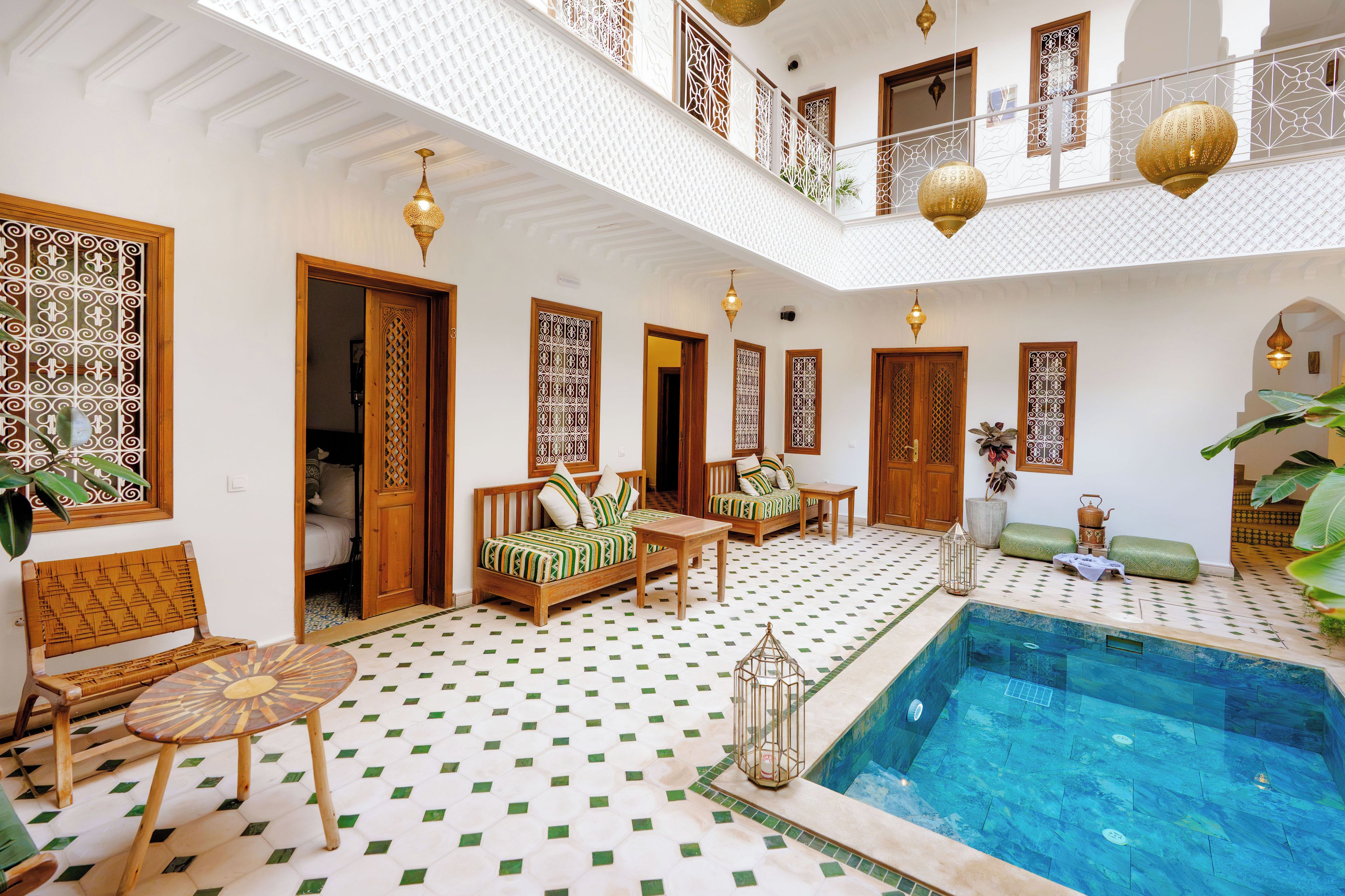 A spacious indoor area with a pool, seating arrangements, and decorative elements.