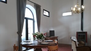 Un coin repas avec une table ronde, des chaises, une plante en pot, un téléviseur à écran plat et une cheminée.