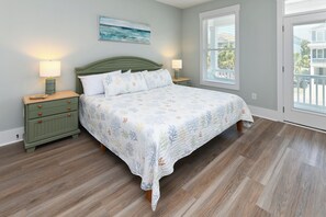 A bedroom with a bed, nightstands, a window, and a door. - 5 Bedroom, Private Pool, Elevator - New Construction - Why Knot (Surfside Beach)