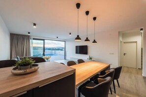 Ein stilvoller Essbereich mit Holztisch, schwarzen Stühlen und Pendelleuchten.