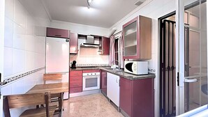 Cocina compacta con microondas, horno y lavabo.
