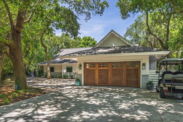 A residential house with a garage, driveway, and a golf cart parked outside.