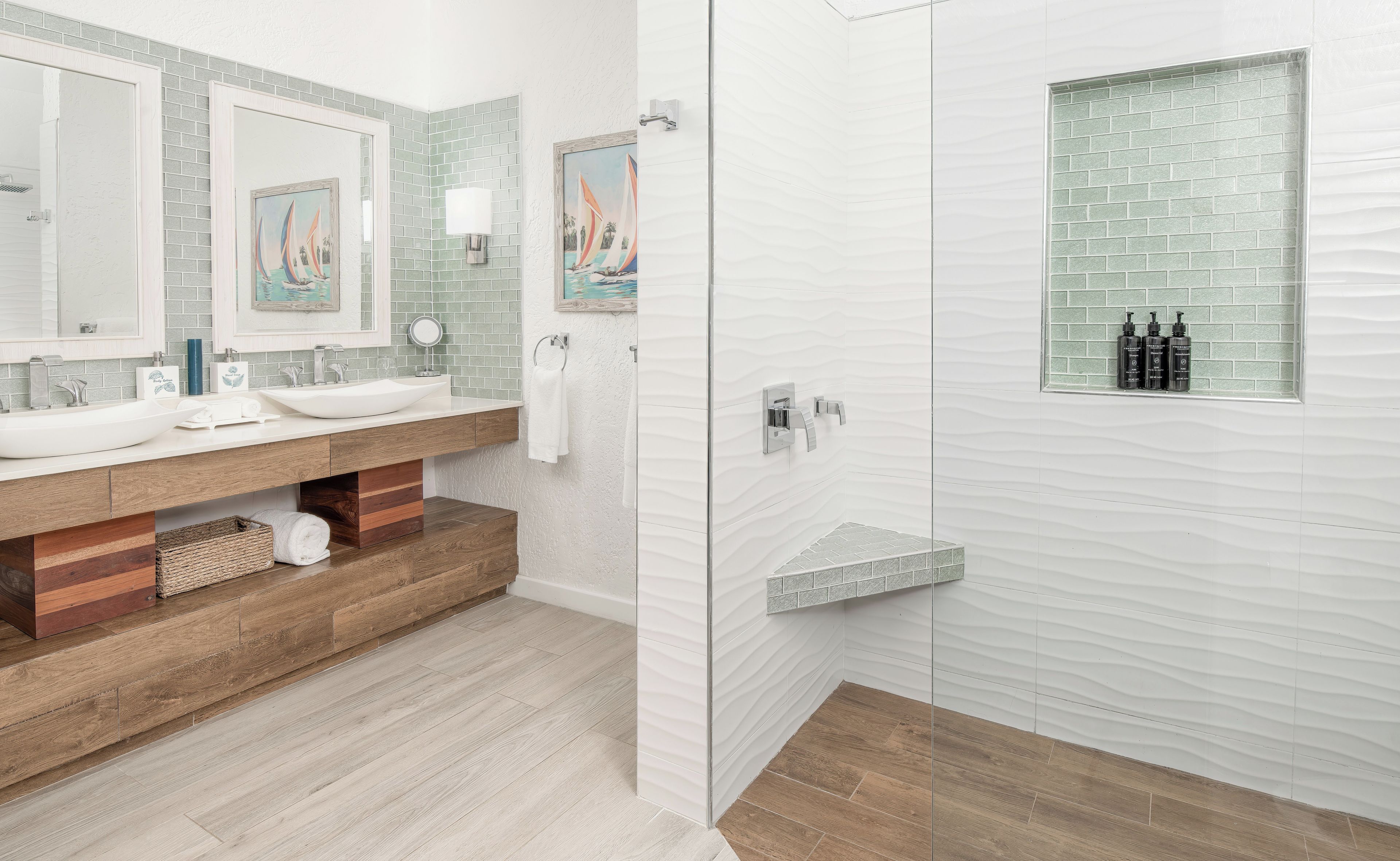 Un baño moderno con un lavamanos grande de color blanco, dos espejos y una cabina de ducha de vidrio.