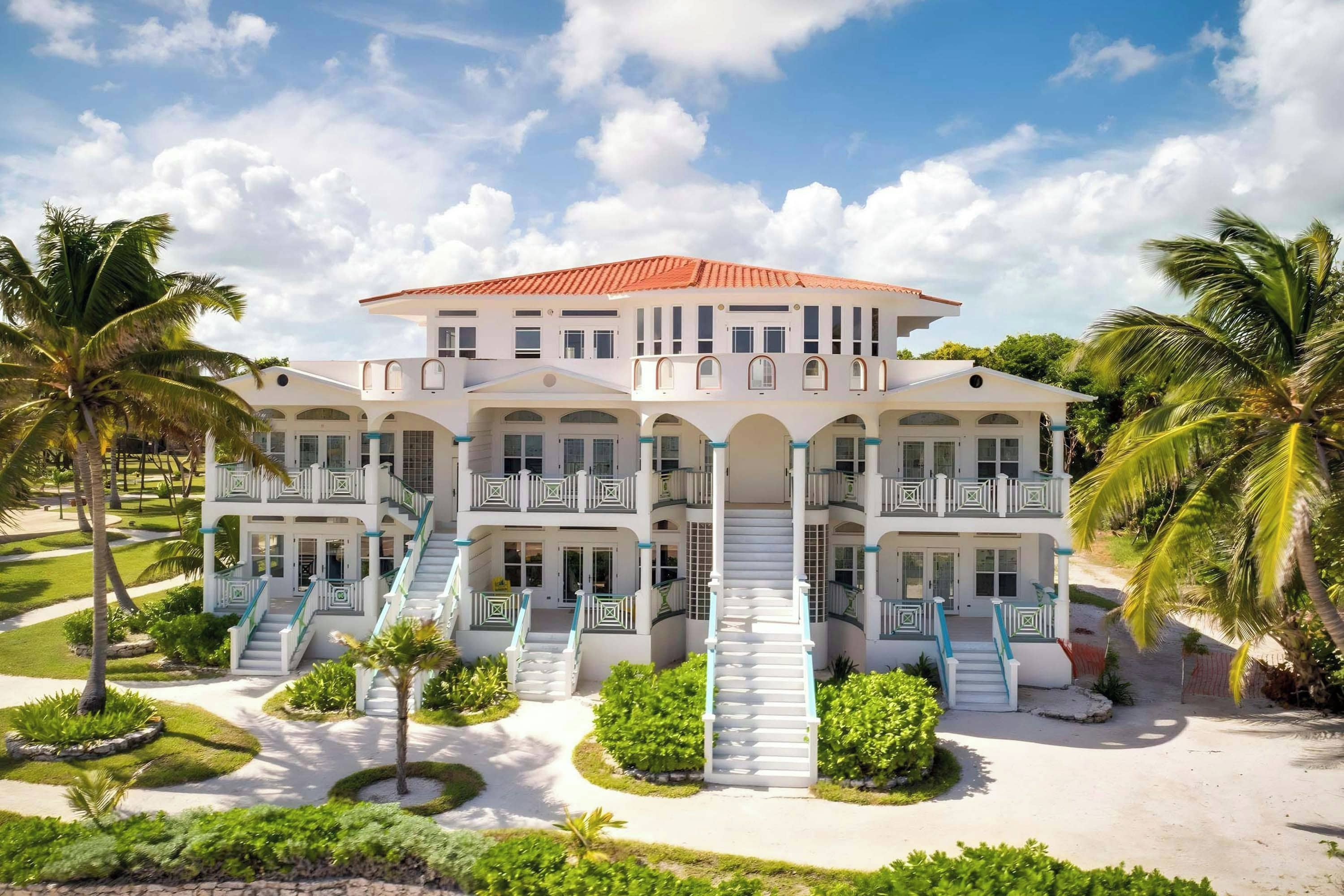 A large, multi-story hotel with a symmetrical facade, multiple balconies, and a central staircase.