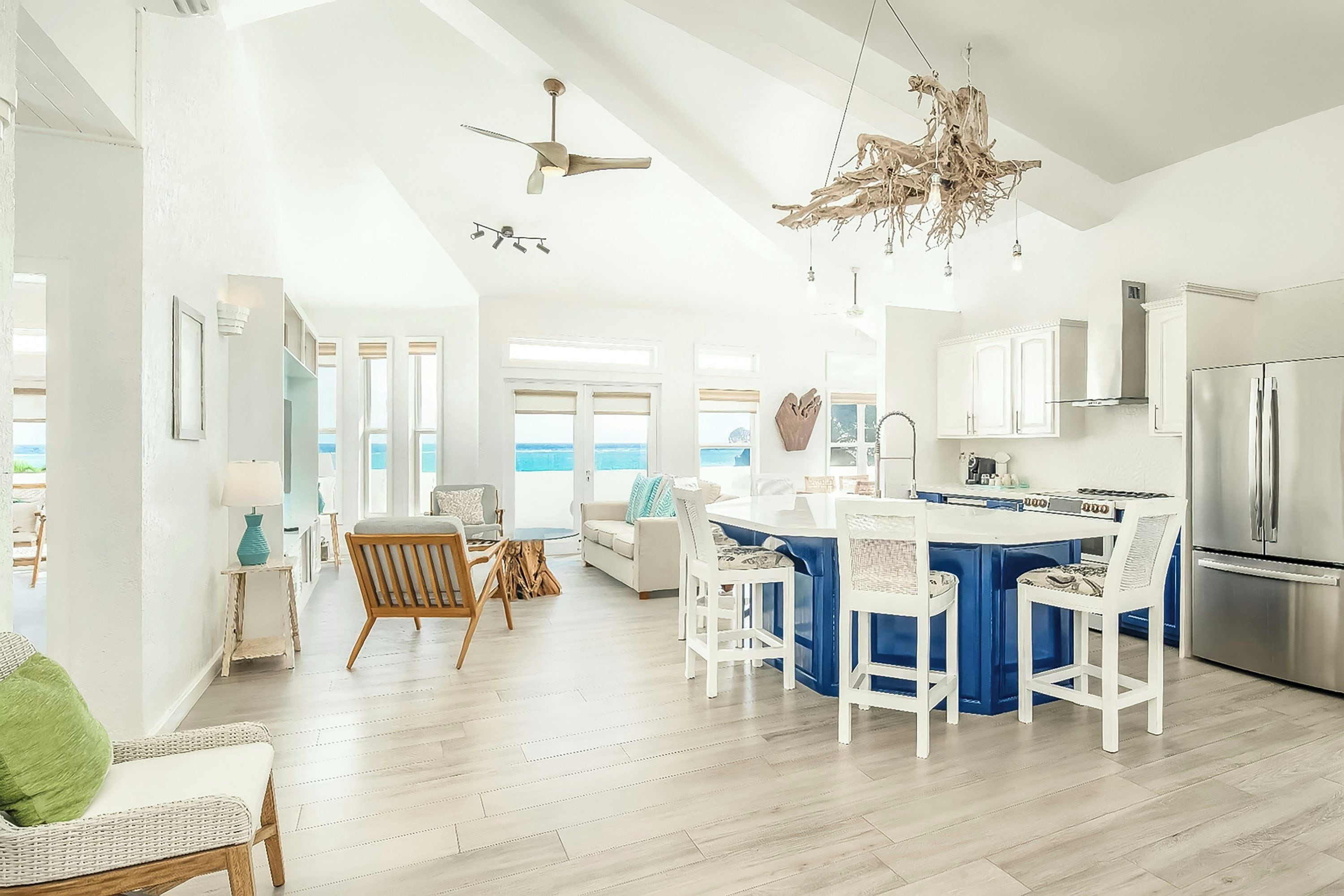 A modern kitchen with a central island, white cabinetry, and a stainless steel refrigerator.