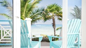 A deck with turquoise chairs and a view of the ocean. - Reef Haven Belize (San Pedro)