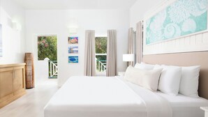 A hotel room with a large bed, a view of the outdoors, and a painting on the wall. - Reef Haven Belize (San Pedro)