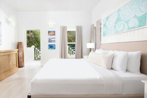 A hotel room with a large bed, a view of the outdoors, and a painting on the wall. - Reef Haven Belize (San Pedro)