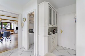A modern kitchen with white cabinetry, a microwave, and a coffee maker. - Apartment 'Fewo Wrede am Sauerland-Radring 1' with Mountain View, Private Terrace & Wi-Fi (Eslohe)