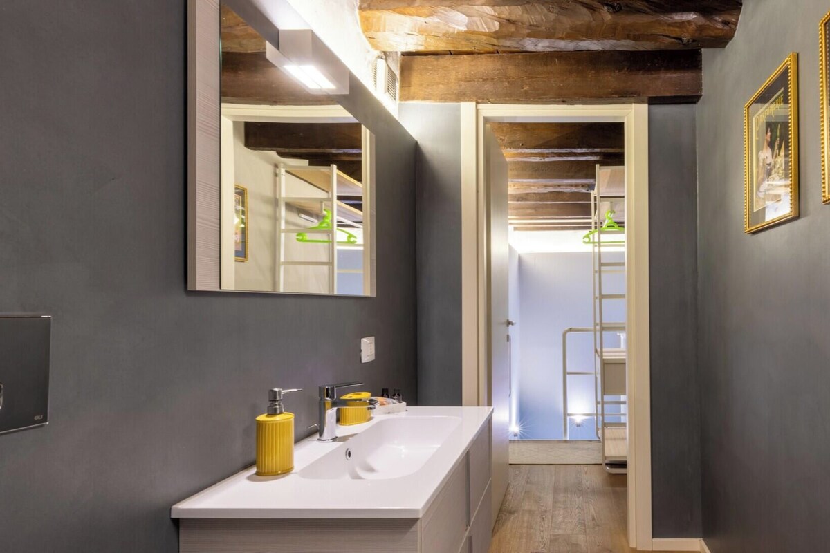 A modern bathroom with a double sink, a mirror, and a towel rack.