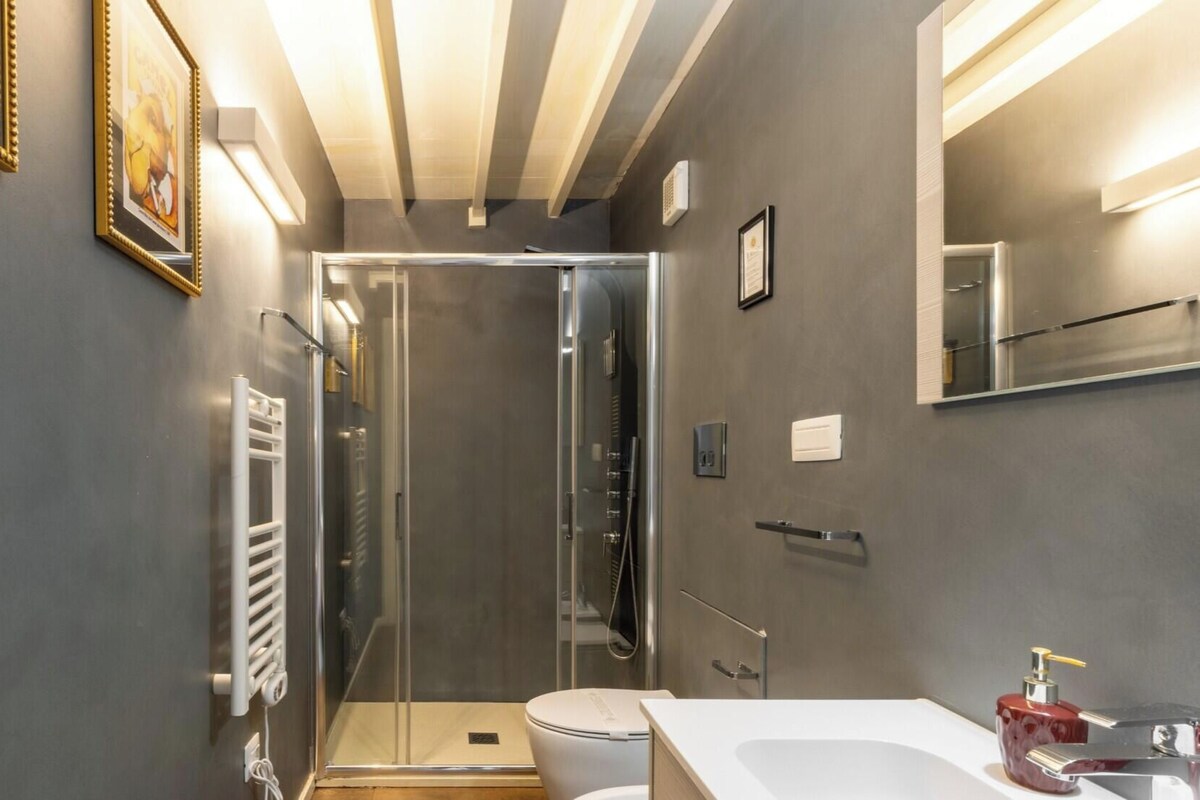 A modern bathroom with a shower, toilet, and sink.
