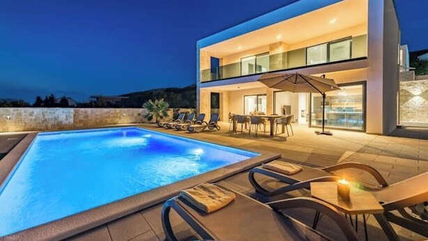 A modern two-story building with a swimming pool, outdoor seating, and a dining area. - Villa Cissa (Stara Novalja)