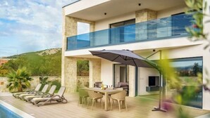 A modern two-story house with a pool, outdoor seating, and a glass balustrade. - Villa Cissa (Stara Novalja)