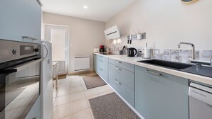 Eine moderne Küche mit eingebautem Backofen, Geschirrspüler und einem großen Fenster.