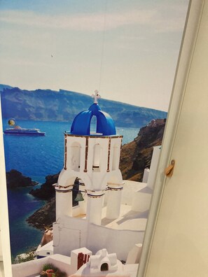 A view of a white building with blue domes, a bell tower, and a ship in the background. - MARADONA HOUSE IN THE SPANISH QUARTERS (Napoli)