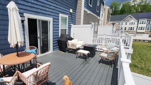 A deck with outdoor furniture, a grill, and a white fence. - The Tolhouse Short or Long-Term (Essex)