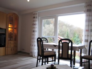 A dining area with a table, chairs, and a cabinet with glass doors. - Apartment 'Naturoase' with Shared Terrace, Shared Garden and Wi-Fi (Waldeck)