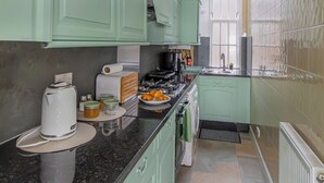 A kitchen with green cabinets, a black countertop, and a white ceiling light. - POOL TABLE/ CINEMA ROOM/ WEEKLY DISCOUNTS (Glasgow)