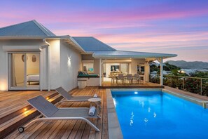 A modern house with a swimming pool, a dining area, and a bedroom with a sliding door. - Villa Alanca • Vue Mer & Accès Plage à Pied (Orient Bay)