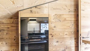 A kitchen with wooden walls and a built-in stove. - Poligrafica 1 House, quiet and comfortable (Cortina d´Ampezzo)