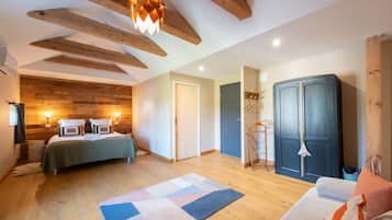 A room with a bed, a wardrobe, a hanging light fixture, and a wooden ceiling.