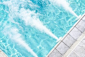 A swimming pool with clear water and a tiled edge.