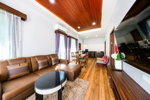 Una sala de estar moderna con un sofá, una mesa de comedor y una zona de cocina.