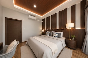A bedroom with a wooden ceiling, a bed with a beige blanket, a nightstand with a lamp, and a wall-mounted air conditioner. - Arterra Haven Aonang Krabi (Krabi)