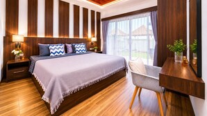 A modern bedroom with a large bed, wooden panel walls, a desk with a mirror, and a view of the outdoors. - Arterra Haven Aonang Krabi (Krabi)