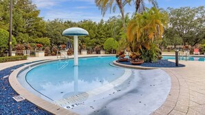 Une piscine avec un palmier et un lampadaire.