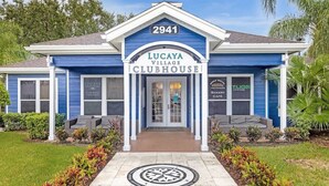 Un bâtiment bleu avec une enseigne indiquant « Lucaya Village Clubhouse » à l’entrée.