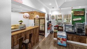 Un bar à sushis avec une enseigne au néon, un espace dédié aux boissons et un coin boulangerie.