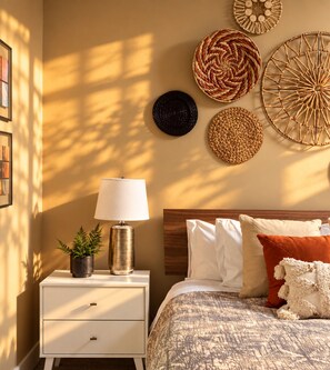 A bedroom with a bed, bedside table, lamp, and wall decorations. - Family-Run, Super Clean Cottage 2 Miles from Asheville (Asheville)