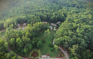 Vue aérienne d’un quartier résidentiel composé de nombreuses maisons, entouré d’une forêt dense.