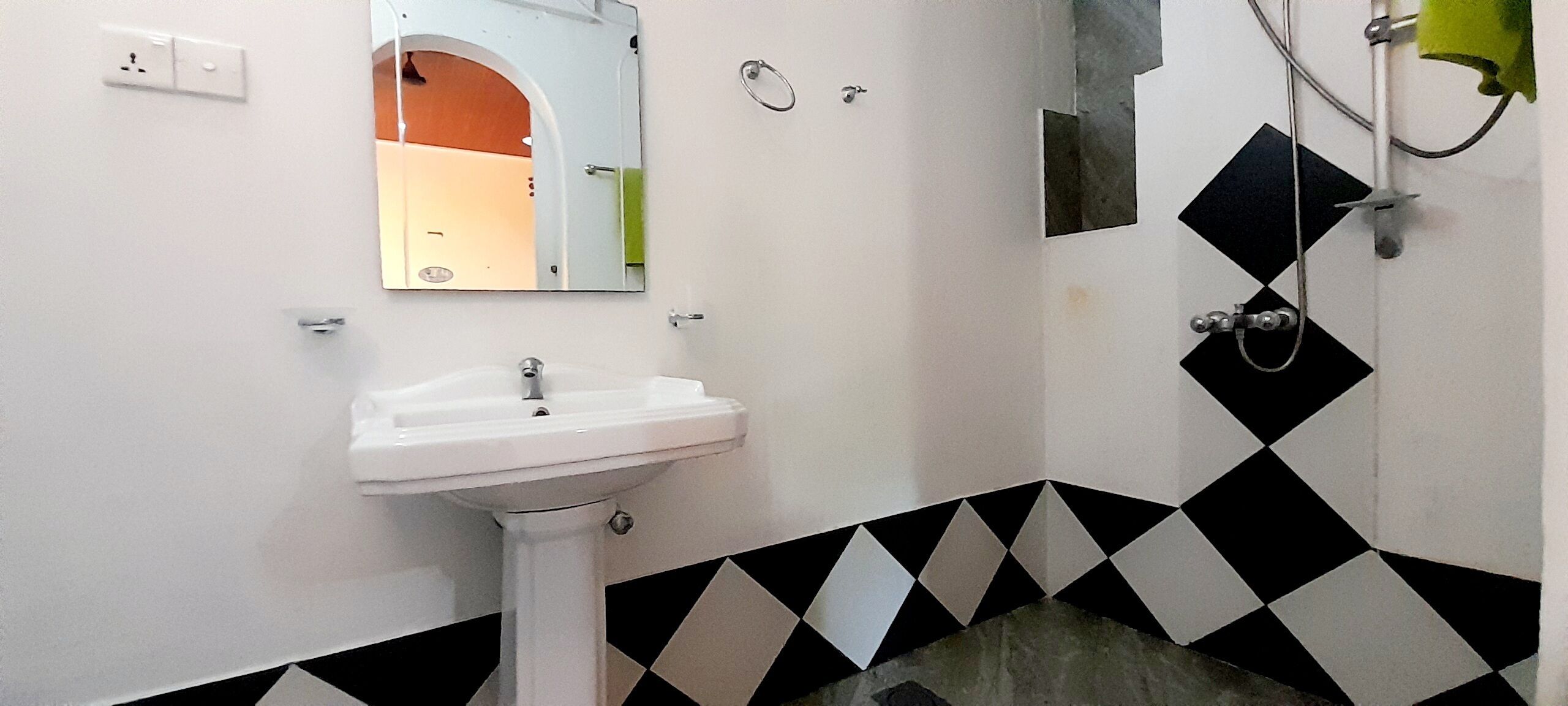 A bathroom with a white sink, a mirror, and a shower.