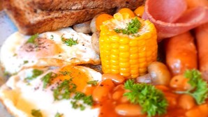 A plate of food with toast, eggs, corn, beans, and ham. - The Fat Mermaid (Mirissa)