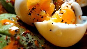 A close-up of a dish with avocado slices, boiled eggs, and a drizzle of sauce. - The Fat Mermaid (Mirissa)