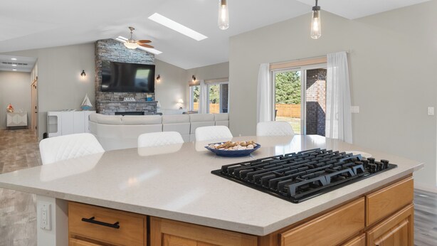 A modern kitchen with a large island, built-in appliances, and a stone accent wall. - Serene coastal ambiance, fenced yard, fire pit, and outdoor furniture! (Seaside)