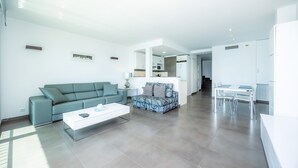 Un salon moderne avec un canapé, une table basse et un coin repas.